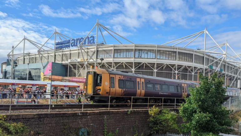 image of a train passing the Ricoh Arena in Coventry