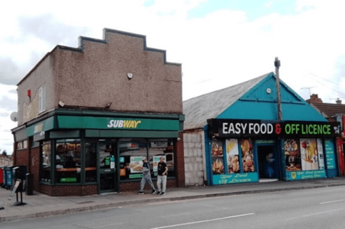 Photograph of Ball Hill today with two buildings in use as a subway and food shop, looking remarkably like the old chapel and tin tabernacle.