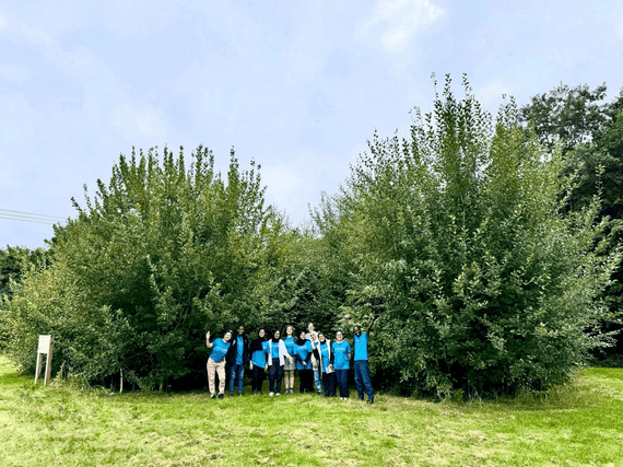 Image of children and young peop;le in front of dense tree growth